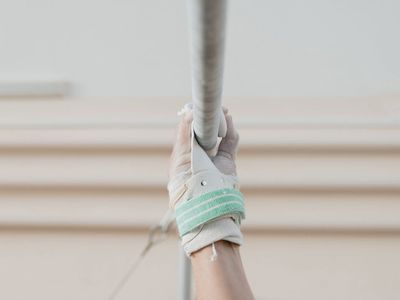 Strong hands gripping a horizontal bar tight